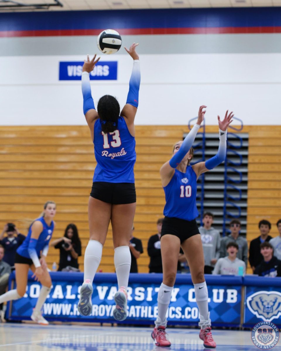 Senior Jasmine Daniels, left, sets the ball for Bre Morgan, right, at the 2025 Girls Volleyball Mudsock game at HSE, on September 11th.